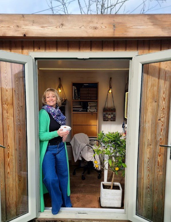 Suz at the door of her home office